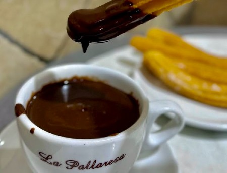 Churros inzuppato in una tazza di cioccolata calda alla Granja La Pallaressa, Barcellona