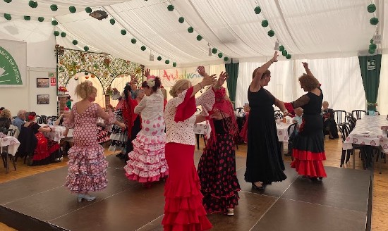 Donne che ballano in abiti tradizionali all'interno di un capannone per la Feria de Abril a Barcellona