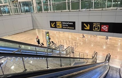 Scale mobili all'interno dell'aeroporto con la segnaletica per la metro