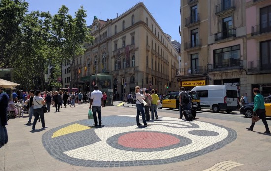 Il Mosaico di Miro sulla Rambla, calpestato da alcune persone che passeggiano